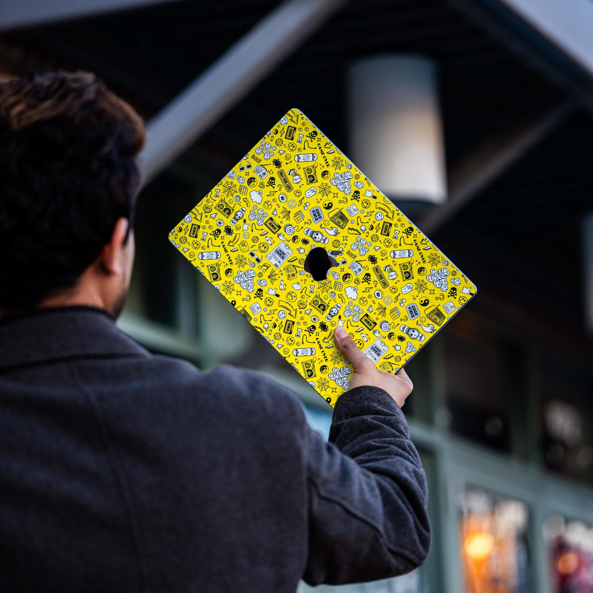 Person holding a laptop with a unique yellow colored wrap.