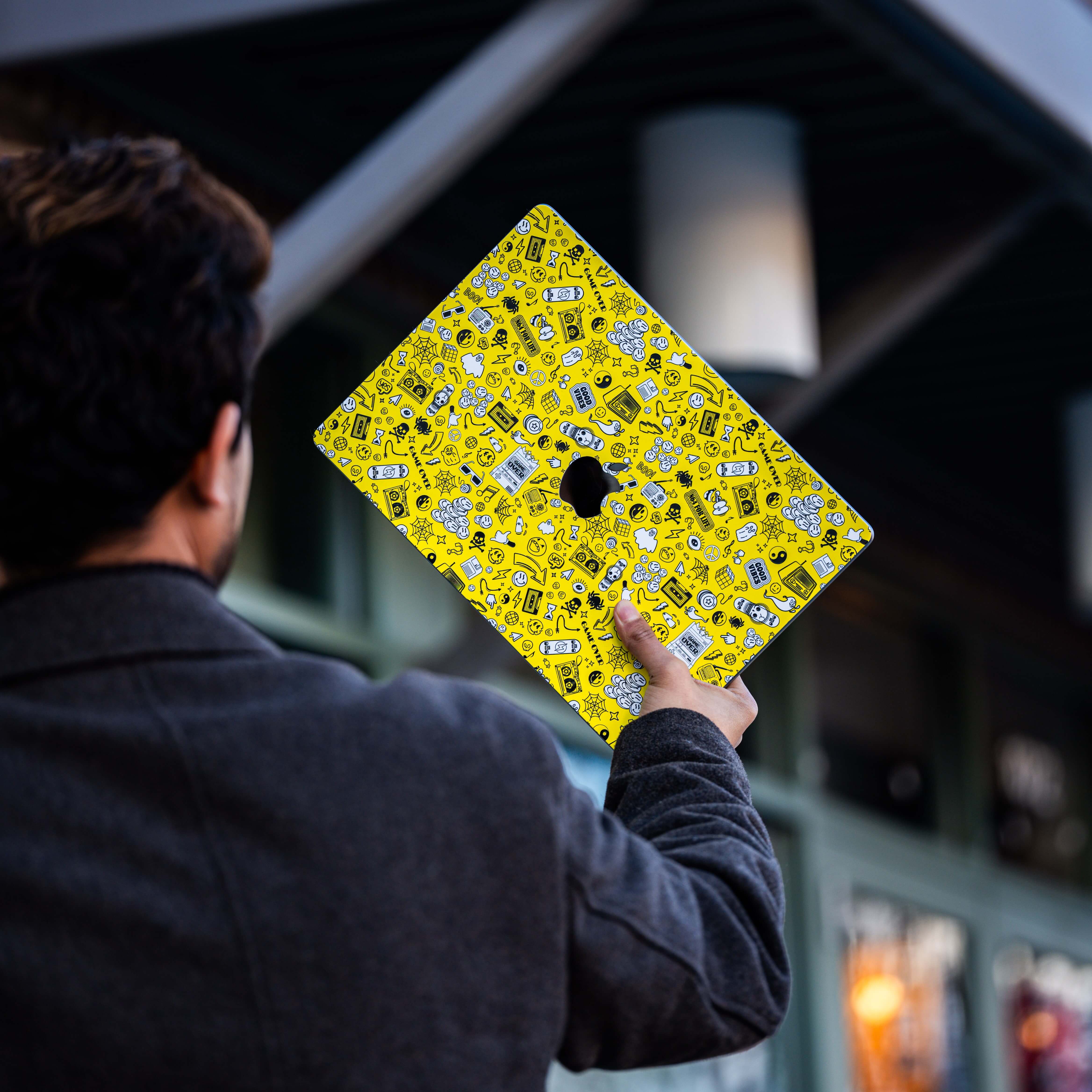 Person holding a laptop with a unique yellow colored wrap.